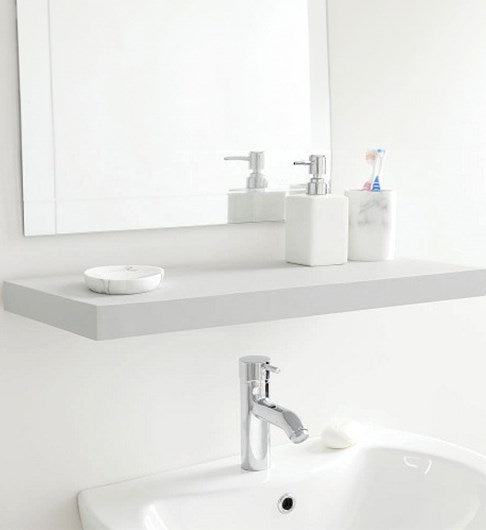 A floating grey wall shelf infront of a wall mirror, over the top of a bathroom sink. On the grey shelf is a handwash dispenser, 2 toothbrushes and a soap dish.